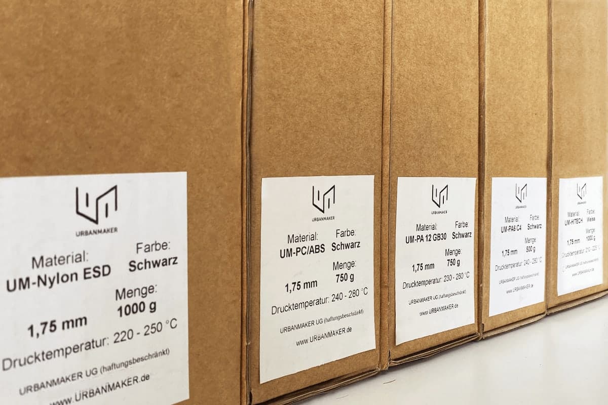 Beschriftete Kartons mit URBANMAKER-Industriefilamenten, vorne UM-Nylon ESD